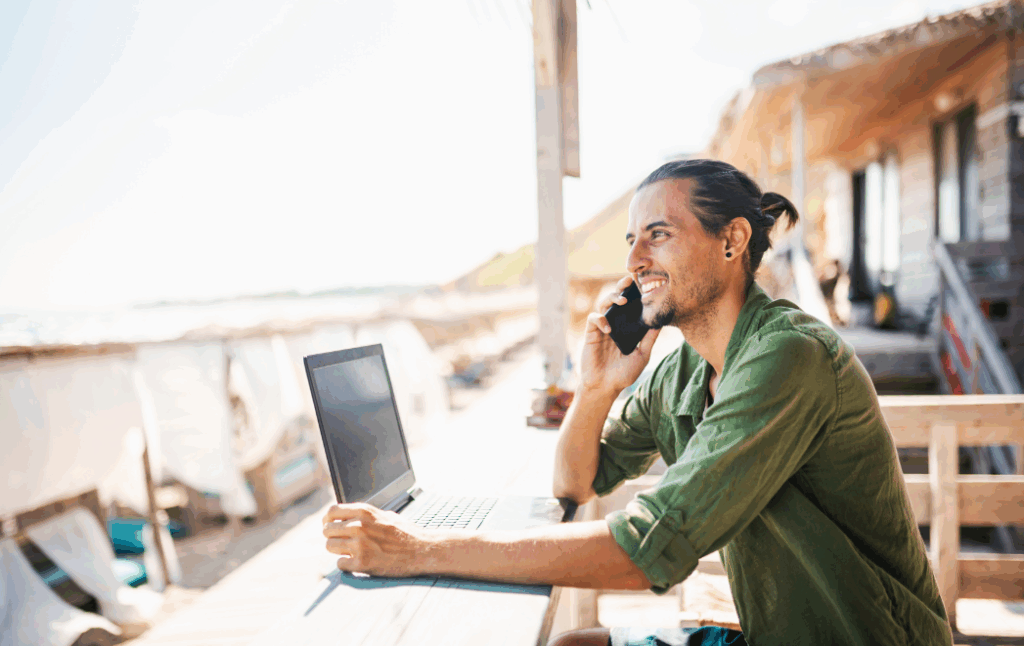 Young man working from a beach cafe thanks to the Digital Nomad Visa